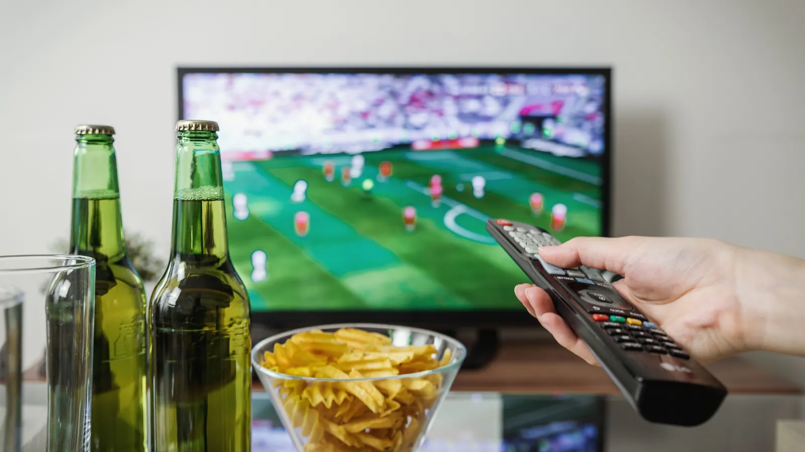 Apple TV 4K box and Siri Remote next to a smart TV displaying an IPTV stream