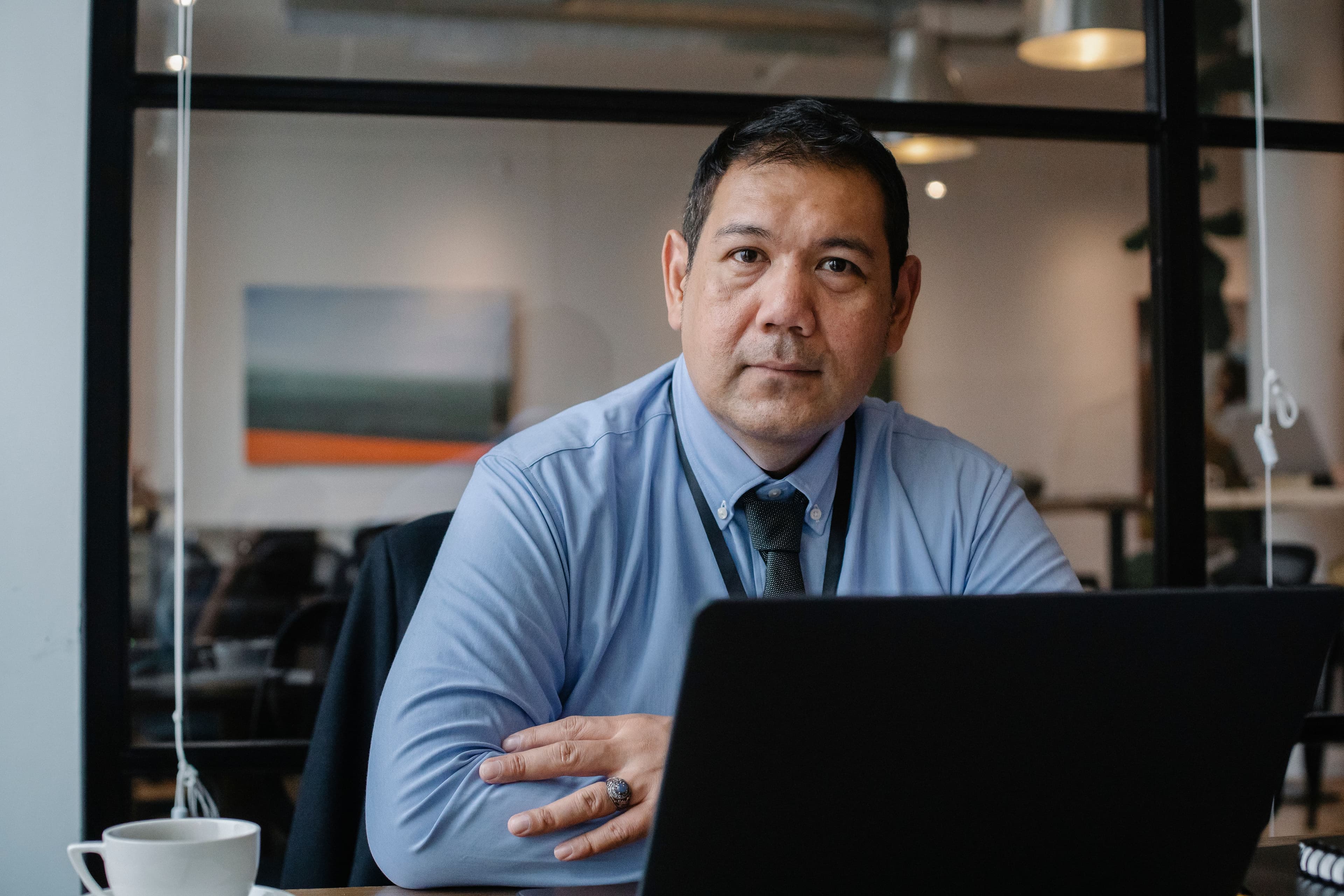 Professional seated at a desk working on a laptop in an office.